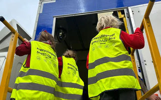 school children in front of a recycling van.