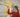 Woman in red top looking at folders on a shelf in an office.